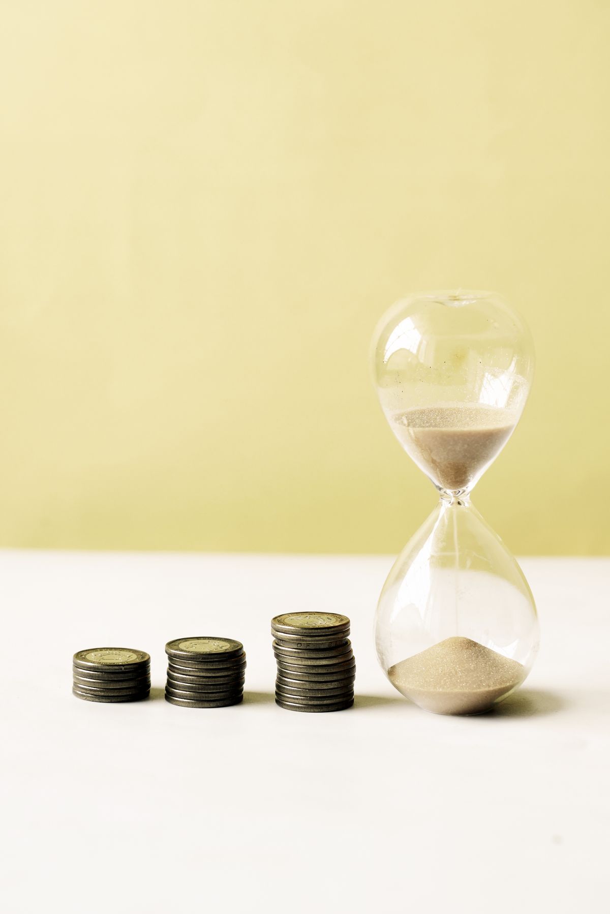 Coins stacked beside an hourglass